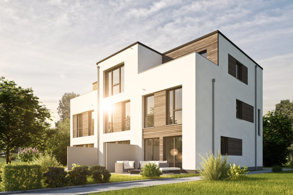 Bilde av nytt hus i funkis stil. Grønn plen og grønne trær i solskinn